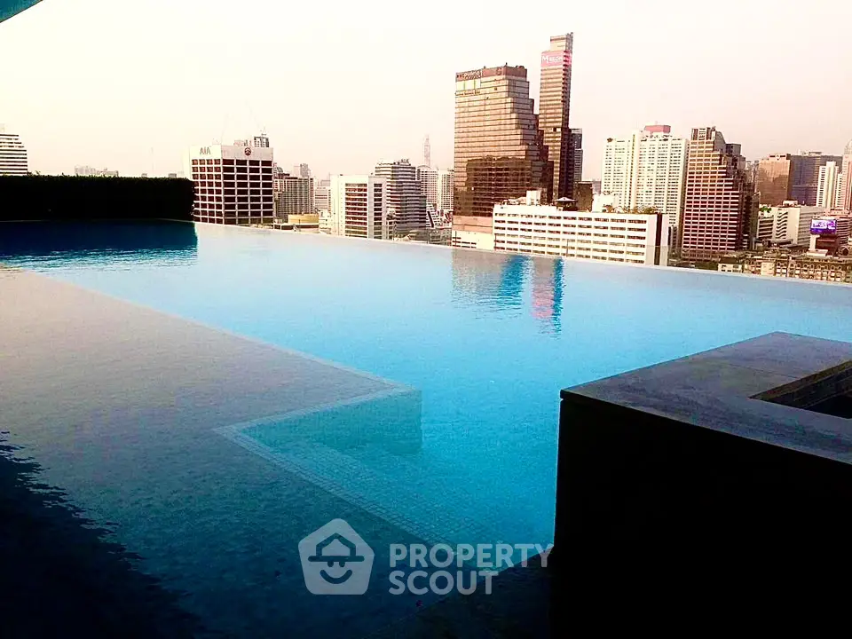 Luxurious rooftop infinity pool with stunning city skyline view, perfect for urban living enthusiasts.