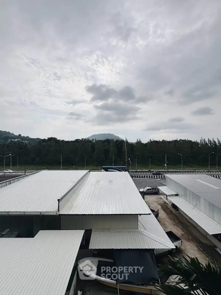 Industrial warehouse with metal roofing and scenic mountain backdrop