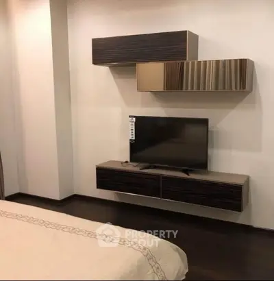 Modern bedroom with sleek wall-mounted TV and stylish storage units
