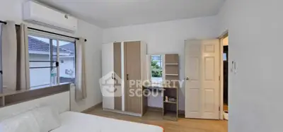 Modern bedroom with wardrobe, desk, and air conditioning in a cozy home.