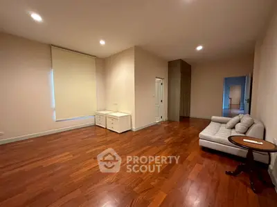 Spacious living room with hardwood floors and cozy sofa in modern apartment.