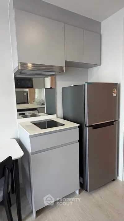 Modern compact kitchen with sleek cabinetry and stainless steel appliances