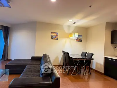 Spacious living room with modern black leather sofa and elegant dining area