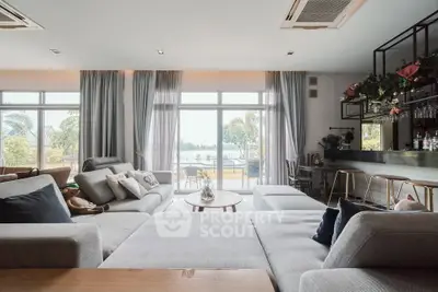 Spacious living room with modern decor and large windows offering a stunning view of the outdoors.