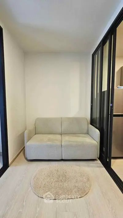 Cozy living room with modern sofa and sliding glass doors, perfect for compact spaces.