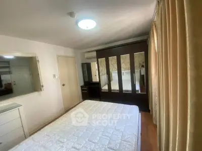 Spacious bedroom with large wardrobe and natural light, perfect for comfortable living.