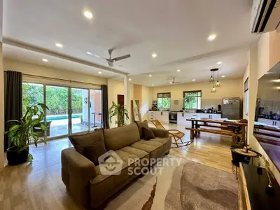 Spacious open-plan living room with modern kitchen and garden view, perfect for family gatherings.