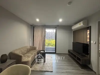 Modern living room with sleek design and balcony view, featuring a comfortable sofa and entertainment unit.