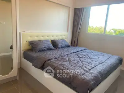 Modern bedroom with stylish bed and large window offering natural light.