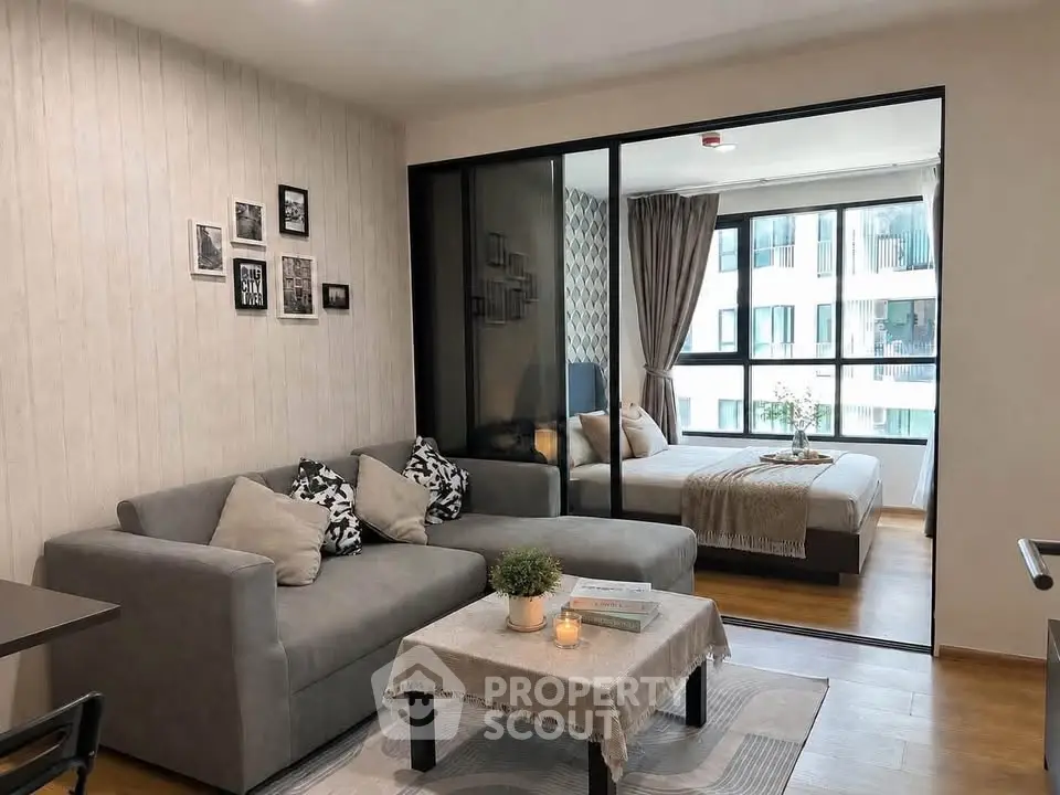 Modern living room with cozy sofa and stylish bedroom view in open layout apartment.