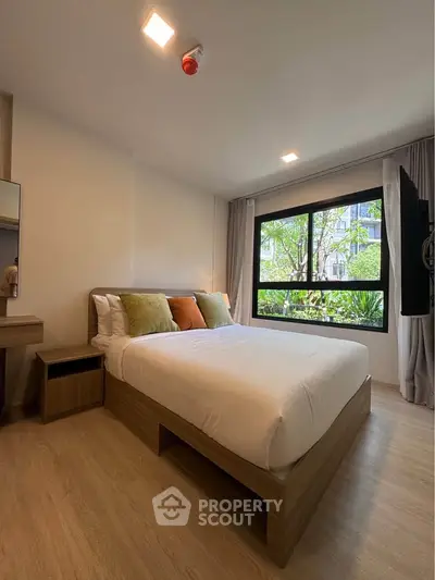 Modern bedroom with large window and stylish decor in a contemporary apartment.