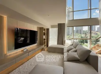 Luxurious living room with large windows and modern decor in high-rise apartment.