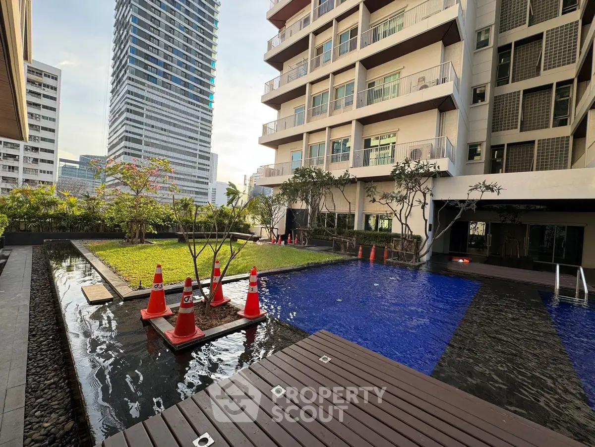 Luxurious condominium with pool and garden in urban setting, perfect for modern living.