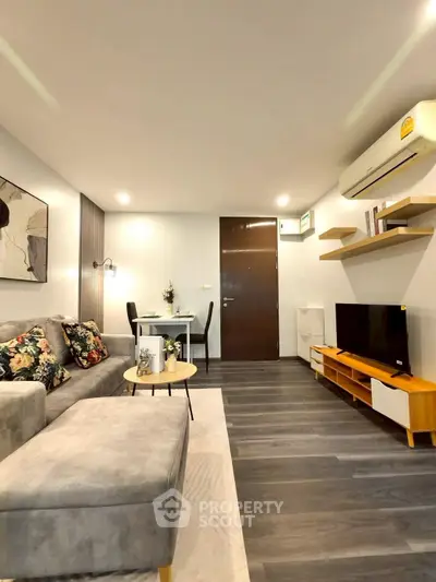Modern living room with stylish decor, featuring a cozy sofa, wall-mounted TV, and elegant dining area.