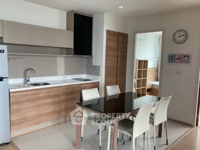 Modern kitchen with sleek cabinetry and dining area in open layout apartment.