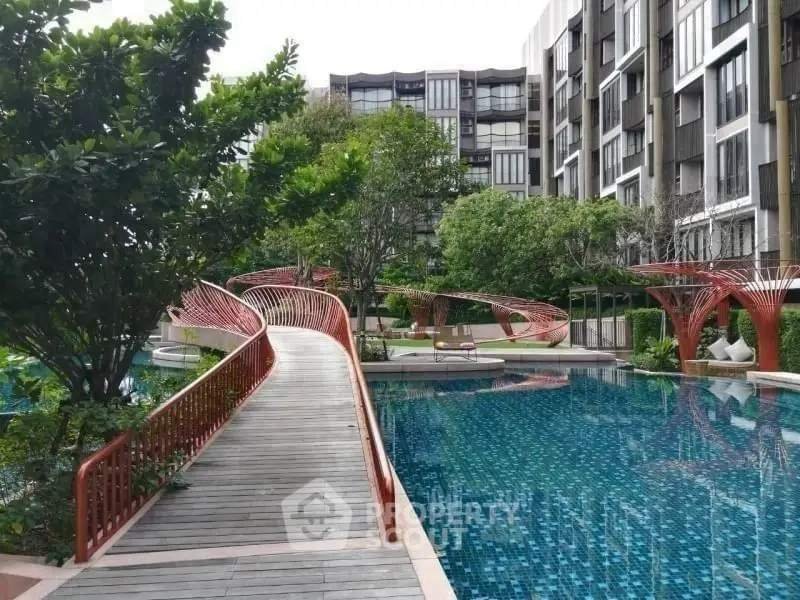 Luxurious modern apartment complex with stunning pool and lush greenery.