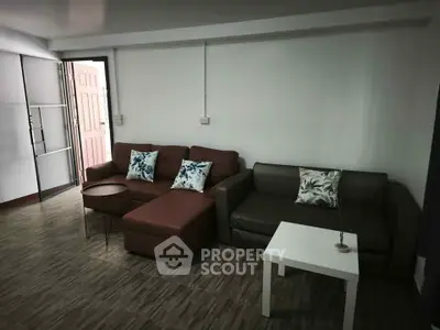 Spacious living room with modern sofas and stylish decor in a cozy apartment.
