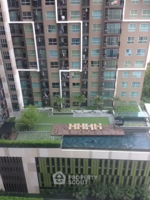 Modern high-rise building with rooftop pool and garden view.