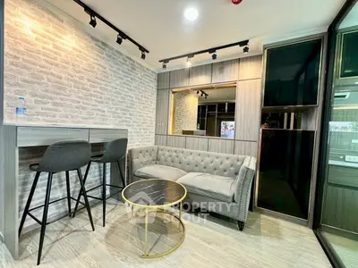 Modern living room with stylish furniture and brick accent wall in a cozy apartment.