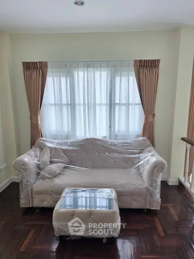 Elegant living room with plush sofa and natural light, perfect for relaxation and comfort.