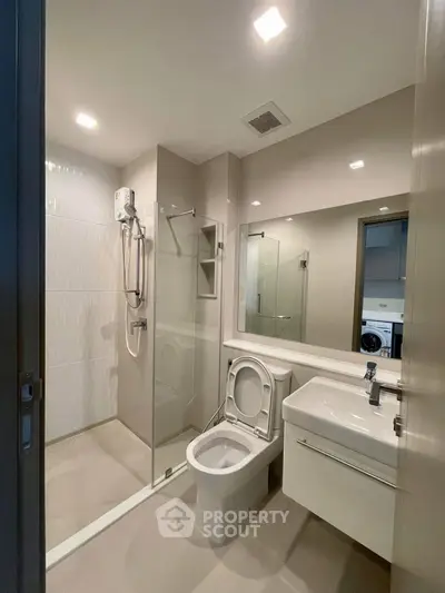 Modern bathroom with glass shower and sleek fixtures in a contemporary apartment.