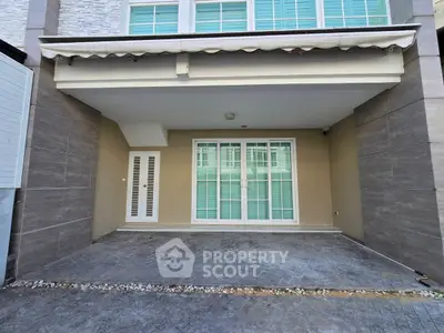 Modern residential building entrance with covered parking space and sleek design.