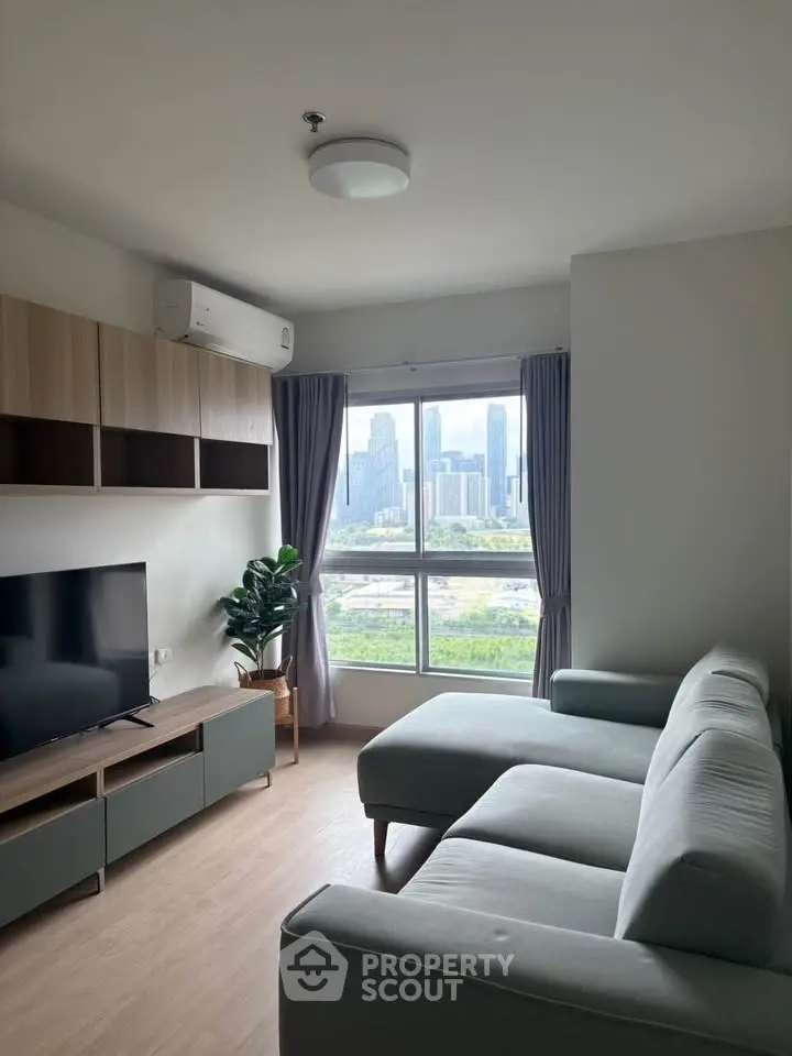 Modern living room with city view, featuring sleek furniture and large window for natural light.