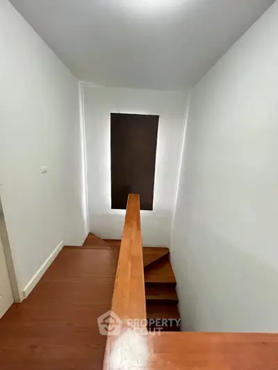 Modern staircase with wooden railing and steps in a minimalist interior design