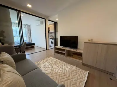 Modern living room with open layout and stylish furniture, featuring a cozy sofa and entertainment center.
