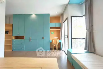Spacious modern bedroom with built-in blue wardrobe and study area