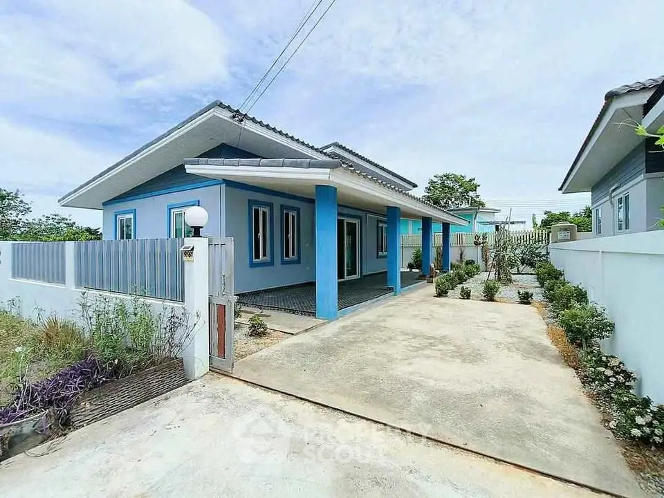 Charming modern blue house with spacious driveway and lush garden