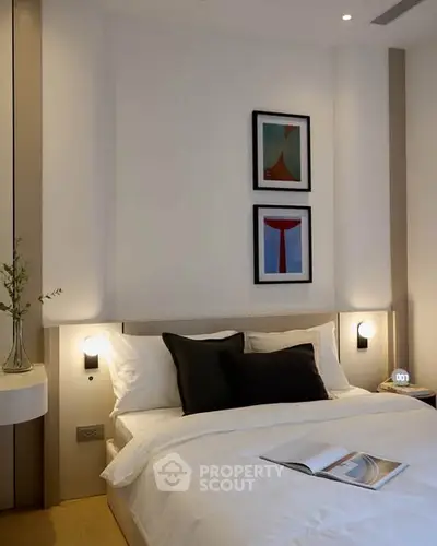 Modern bedroom with stylish decor and cozy ambiance, featuring elegant wall art and soft lighting.