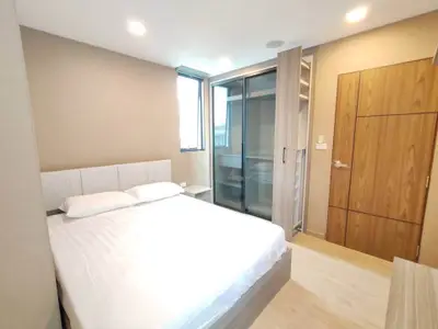 Modern bedroom with sleek design and ample natural light, featuring a comfortable bed and stylish wardrobe.