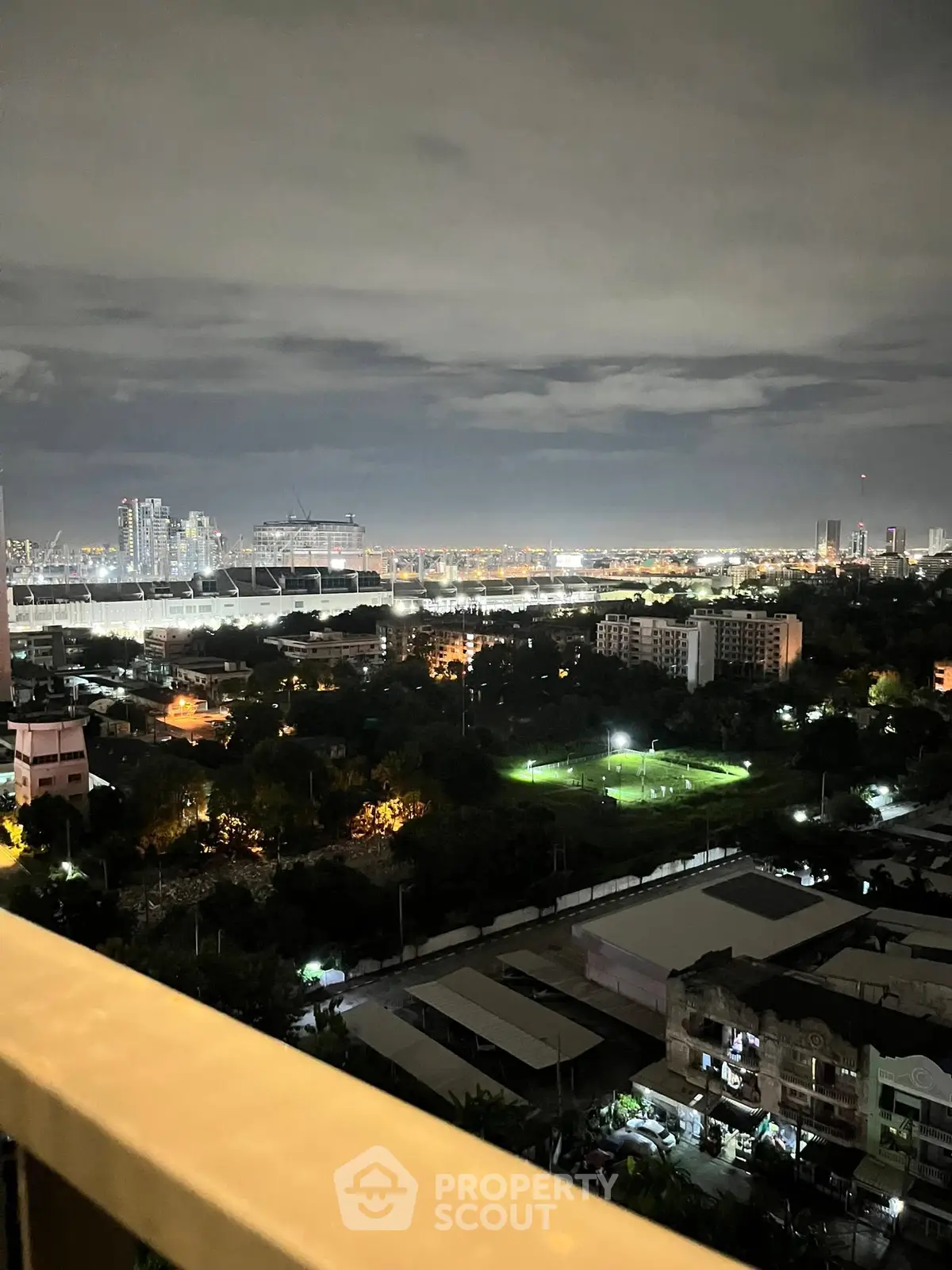 Stunning cityscape night view from high-rise balcony overlooking urban skyline.
