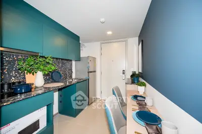 Modern kitchen with teal cabinets and stylish dining area in a compact apartment.