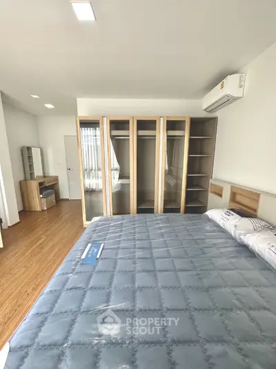 Spacious bedroom with modern wardrobe and air conditioning in a stylish apartment