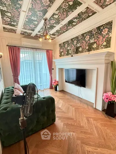 Charming living room with floral ceiling, elegant decor, and cozy green sofa.