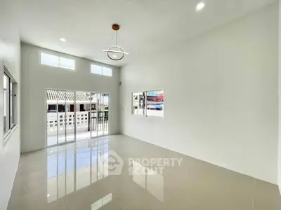 Spacious modern living room with large windows and high ceiling