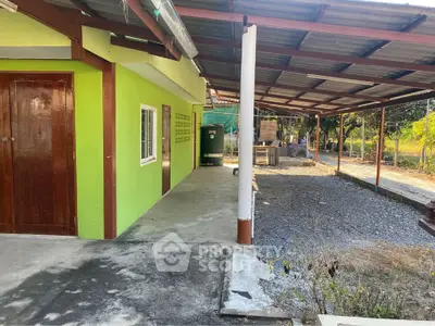 Charming green exterior house with covered patio and spacious outdoor area.