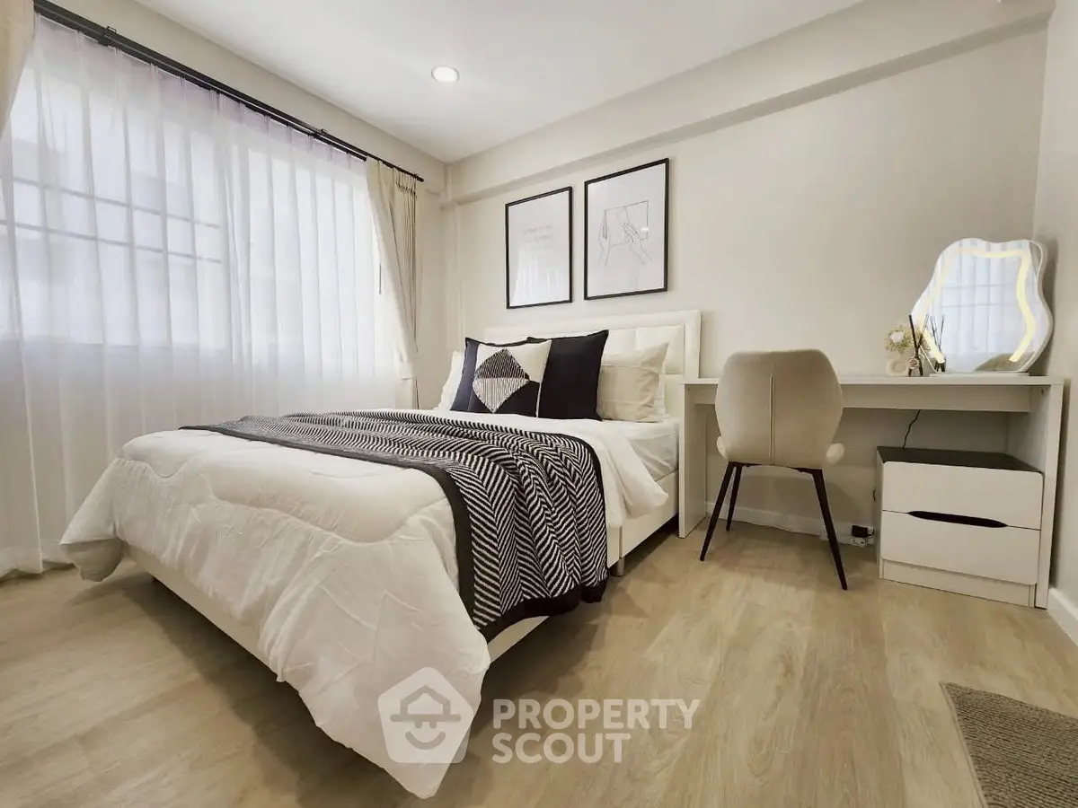 Modern bedroom with stylish decor and natural light, featuring a cozy bed and elegant furnishings.