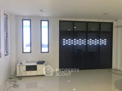 Spacious modern living room with sleek tiled flooring and large windows for natural light.