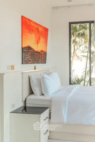 Bright and airy bedroom with modern decor and large window view.