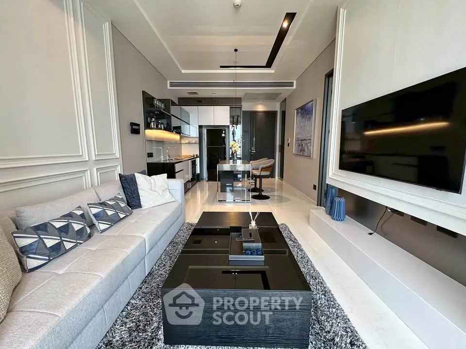 Luxurious modern living room with sleek furniture and large TV, perfect for relaxation and entertainment.