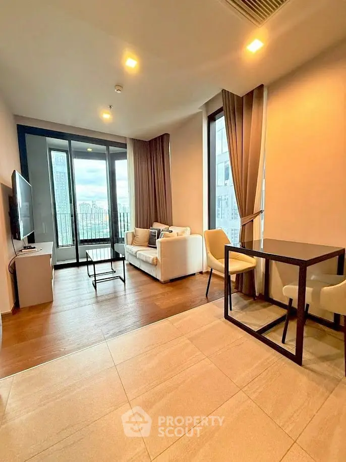 Spacious modern living room with large windows and city view, featuring elegant furniture and wooden flooring.