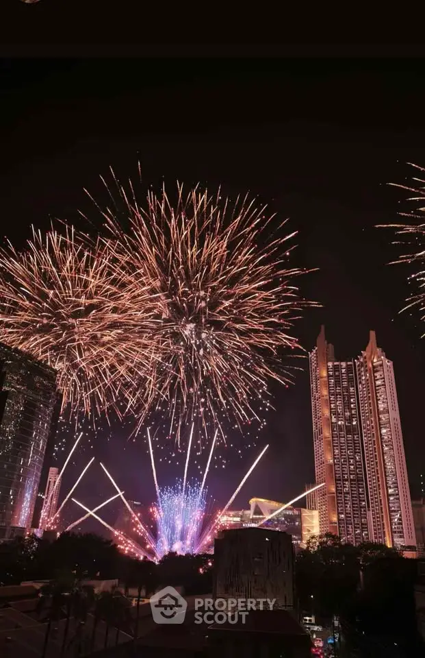 Spectacular fireworks display over modern city skyline with tall buildings at night.