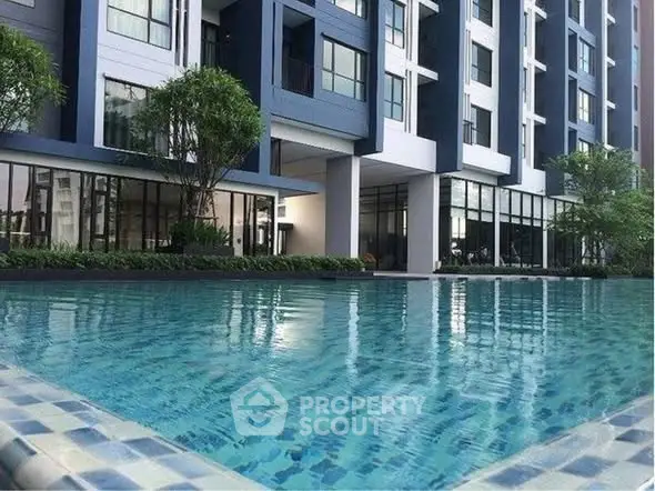 Modern apartment building with a luxurious swimming pool and sleek architectural design.