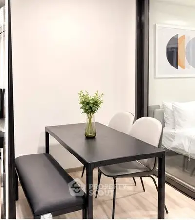 Modern dining area with sleek black table and stylish chairs in a contemporary apartment.