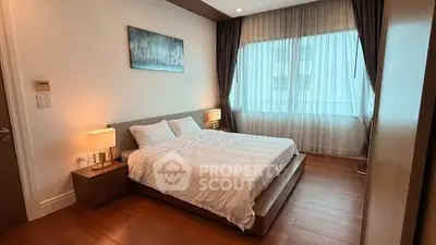 Spacious bedroom with modern decor and large window for natural light.
