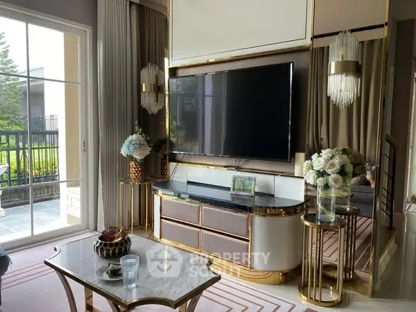 Luxurious living room with elegant decor and large TV, featuring a stylish coffee table and garden view.