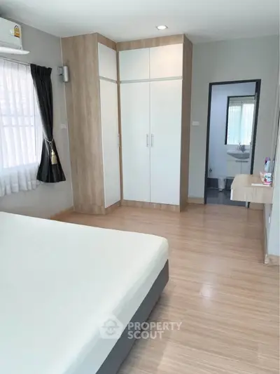 Spacious bedroom with modern design and ensuite bathroom in a stylish apartment.
